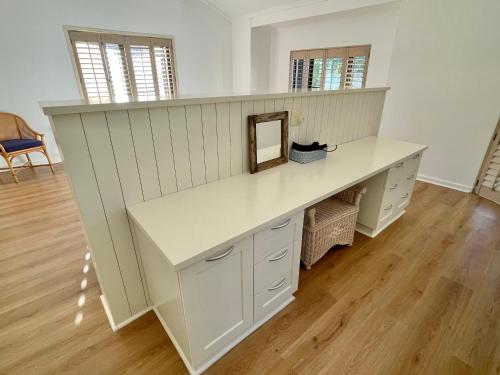 Un gran escritorio blanco con un espejo. en Ocean Mooring Beach Apartment " no sea view, 50m from beach", en Port Alfred