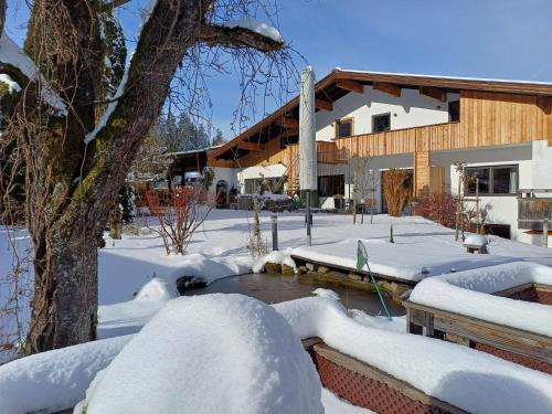 a yard covered in snow next to a building at Landhaus Almdorf in Sankt Johann in Tirol