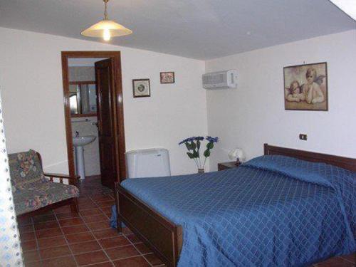 a bedroom with a blue bed and a chair at La Casa Sull'aia,AV in Santo Stefano del Sole