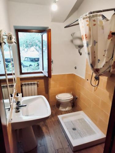 a bathroom with a sink and a toilet and a window at La Stella Alpina in Tagliacozzo