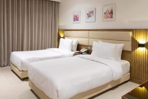 a hotel room with two beds and a telephone at Pearl Inn Paradise Hotel in Karachi