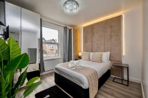a hotel room with a bed and a large window at Gilded Nooks in Croydon