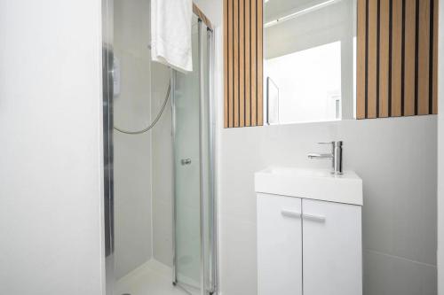 a bathroom with a shower and a sink and a mirror at Gilded Nooks in Croydon