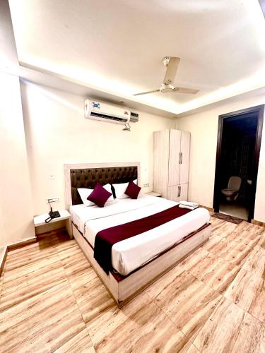 a bedroom with a large bed with red pillows at Hotel Surya Residency in Dehradun