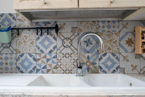 a white sink in a kitchen with tiles on the wall at Sophie's Choice in Rome