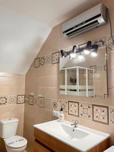 a bathroom with a sink and a toilet and a mirror at InHome Central Studio in Montilla
