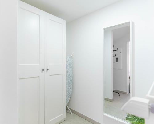 a room with white cabinets and a mirror at COMFY APARTMENT Wesseling in Wesseling