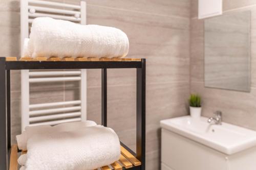 a bathroom with a shelf with towels and a sink at COMFY APARTMENT Wesseling in Wesseling