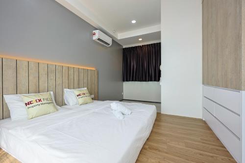 a bedroom with a large bed with white sheets and pillows at Urban Suites Penang by Nexx Field in Jelutong