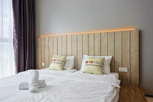a bedroom with a white bed with two pillows at Urban Suites Penang by Nexx Field in Jelutong