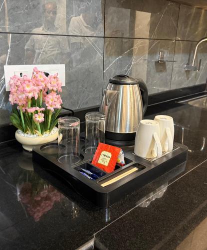 a tray with a coffee pot and cups and flowers at Coco Cabana in Varanasi