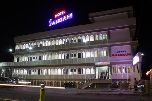 a building with a neon sign in front of it at Hotel Sangam in Kanyakumari