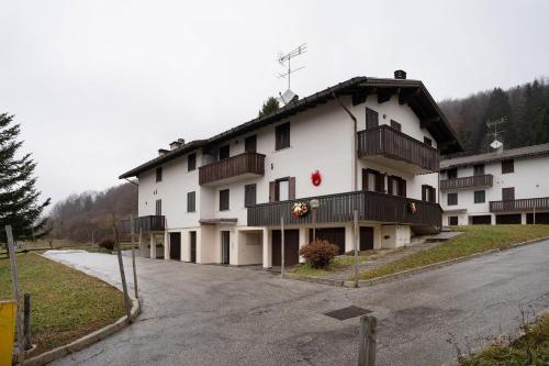 a large white building with balconies on a street at Appartamento Eva in Folgaria