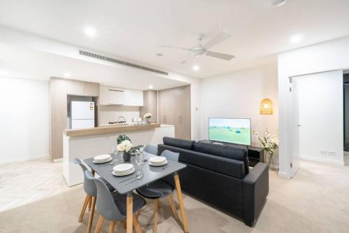 a living room with a black couch and a table at Central 2BR-2BA Resort-Style Retreat In Hamilton M21 in Brisbane