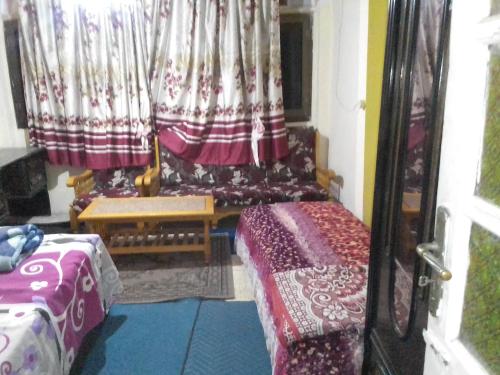 a room with two beds and a window with curtains at كمب شيزار ادفو 35 in Alexandria