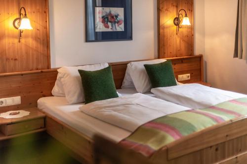 a bedroom with a wooden bed with two green pillows at Eisbacherhof in Schladming