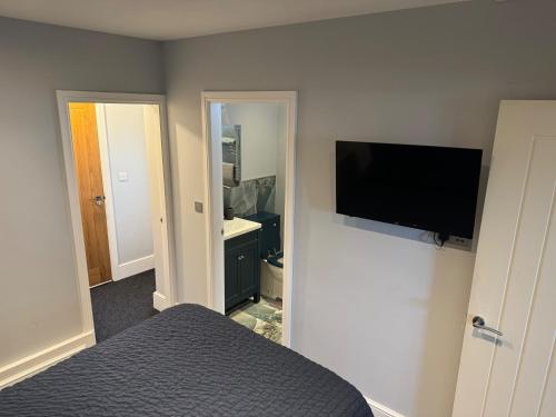 a bedroom with a bed and a flat screen tv at Cozy Apartment in Stoke-on-Trent One double bed in Stoke on Trent