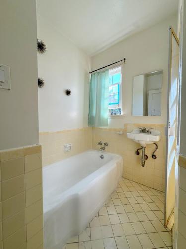 a bathroom with a white tub and a sink at Bargain Beverly Hills 3 Bedroom in great area 5 minutes to Rodeo Drive in Los Angeles