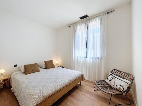 une chambre avec un lit, une chaise et une fenêtre dans l'établissement Villa de l'Ange en Provence, à Eyragues