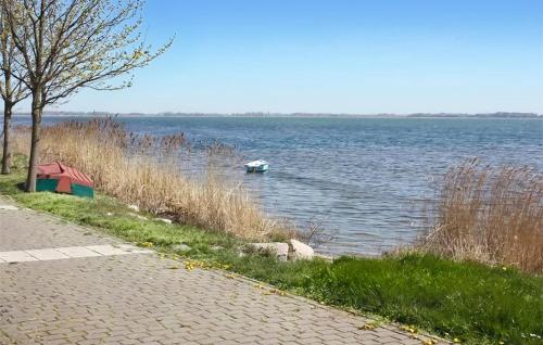 a boat in the water next to a lake at Ferienhaus Dranske Auf Rügen in Dranske