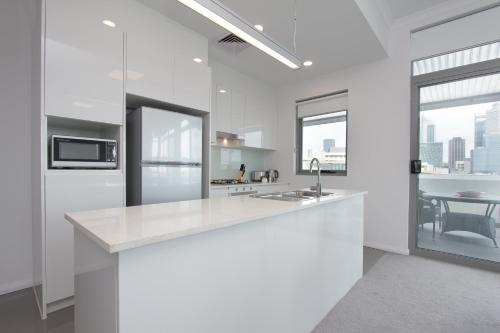 a white kitchen with a counter and a sink at 188 Apartments in Perth
