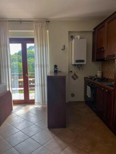 a kitchen with a counter and a refrigerator and a window at Binario 11 in Roccaraso