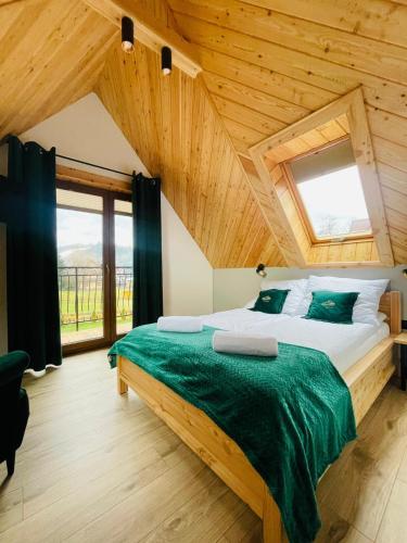 a bedroom with a large bed in a wooden house at Gąsienicowy Widok in Poronin