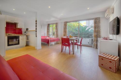 un salon avec un canapé et une table avec des chaises dans l'établissement Studio spacieux 3min plages croisette A0B123, à Cannes