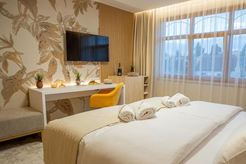 a hotel room with a bed and a desk and a television at Hotel Kamélia in Žilina