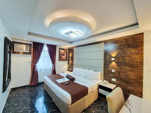 a hotel room with a large bed and a table at Presken K-ONE in Ikeja