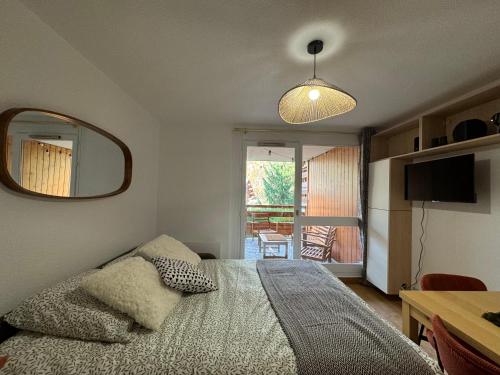 une chambre avec un lit, un miroir et une table dans l'établissement Snow & Sun, Morzine, 4 personnes, à Morzine