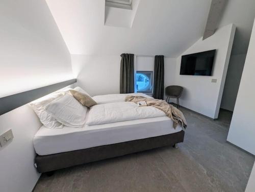 een slaapkamer met een bed en een tv erin bij Villa Sembenini Loft in Riva del Garda