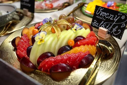 a cake with fruit on a plate on a table at Hotel Kamélia in Žilina