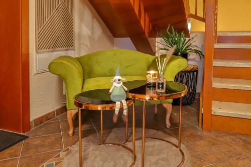 a living room with a green couch and a table at Hotel Kamélia in Žilina