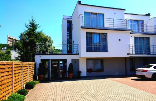 a white house with a car parked in front of it at Willa Akacja in Gdynia