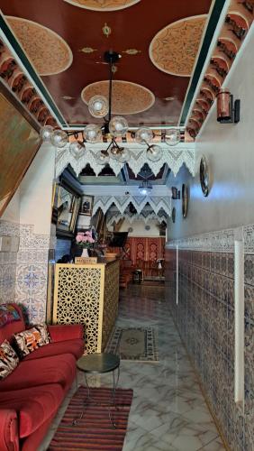 a living room with a red couch and a table at Hotel Riad Fantasia in Marrakech