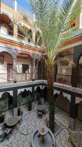a courtyard with a palm tree in a building at Hotel Riad Fantasia in Marrakech