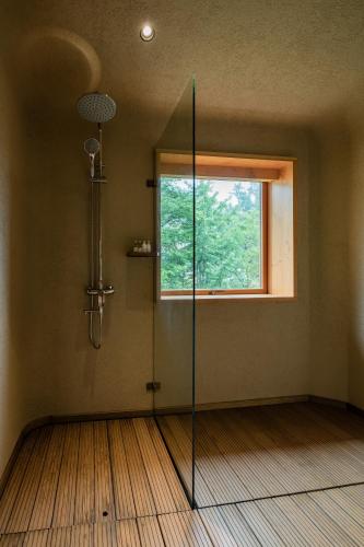 a bathroom with a shower and a window at 大山初里 Origin Villa Village Hotel&Resort in Tonglu