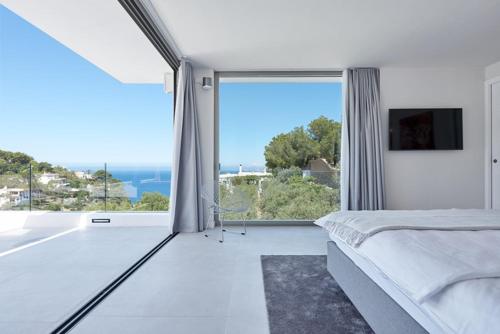 a bedroom with a bed and a large window at Casa Cristiano in Sant Josep de Sa Talaia