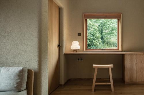 a stool in a room with a window at 大山初里 Origin Villa Village Hotel&Resort in Tonglu