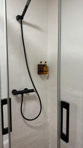 a shower with a hose attached to a wall at Apartamentos Jerez Siglo XIX in Jerez de la Frontera