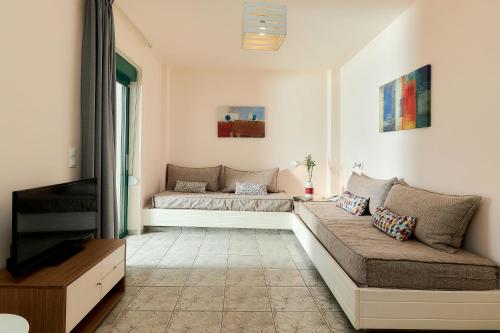 a living room with two beds and a flat screen tv at Bella Vista Hotel "by Checkin" in Hersonissos