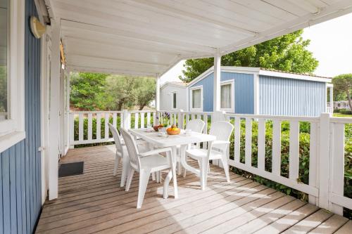 a white porch with a table and chairs on it at Club del Sole Vigna sul Mar Family Collection in Lido di Pomposa