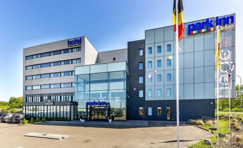 a large building with a sign on the front of it at Park Inn by Radisson Liege Airport in Liège