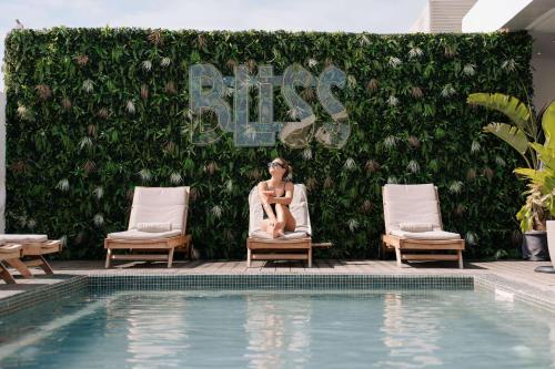 a woman sitting in a chair next to a swimming pool at Radisson Hotel Casablanca Gauthier La Citadelle in Casablanca