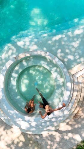 two people are swimming in a swimming pool at Parada Beach Camp in El Nido