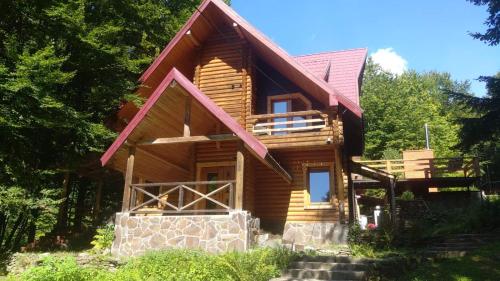 a log cabin with a red roof at Voronins Retreat House in Lumshory