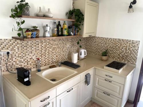 Jaffa Rooftop Studio with Sea Views في تل أبيب: مطبخ مع حوض وطاولة عمل