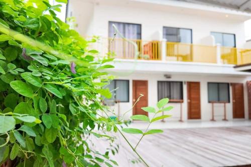 a white building with a balcony and a fence at Sidewalk Boutique Hotel in Ko Samed