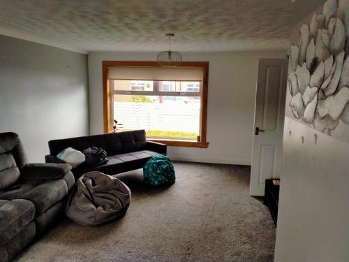 a living room with a couch and a window at Loch Leven Getaway in Kinross